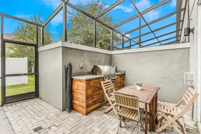 a patio with a table and chairs and a grill at Cozy home in the best location of orlando in Kissimmee