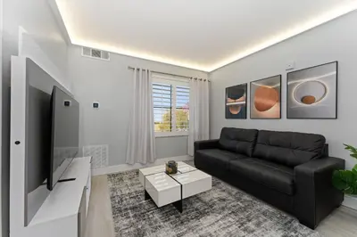 a living room with a black couch and a tv at Spacious 1BR near Universal I-Drive in Orlando