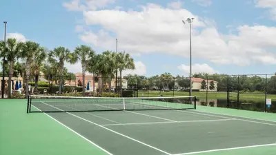 a tennis court with a tennis net on it at Upstay Family Home w Resort Access & Private Pool in Kissimmee