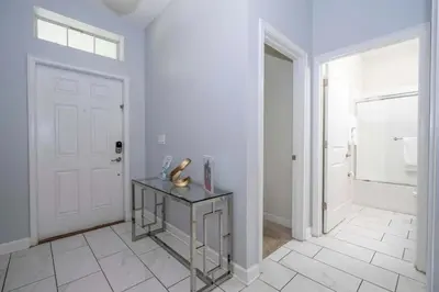 a white bathroom with a glass table and a door at Villa 6Q Storey Lake – 10 min da Disney in Kissimmee