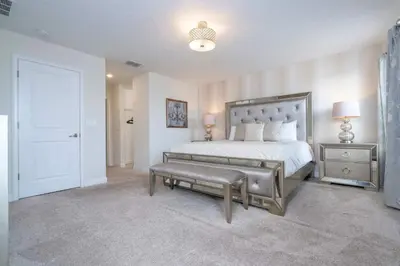 a bedroom with a bed with a bench and a door at Villa 6Q Storey Lake – 10 min da Disney in Kissimmee