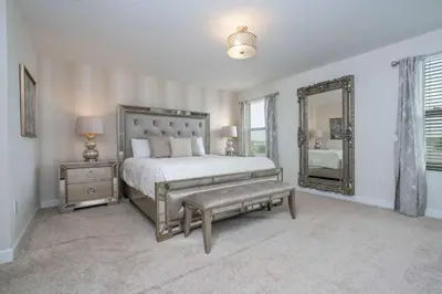 a bedroom with a large bed and a mirror at Villa 6Q Storey Lake – 10 min da Disney in Kissimmee