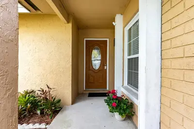 a front door of a house with flowers at 9 min to Disney Entrance-Peaceful Single Family House in Kissimmee