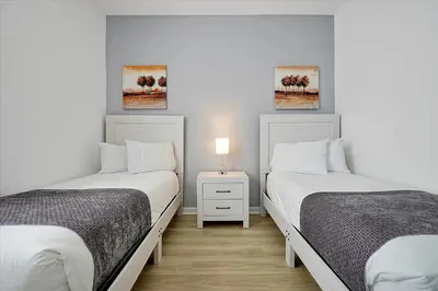 two beds in a room with white walls at Luxury Epic Universe Condo, Vista Cay - 3028 in Orlando