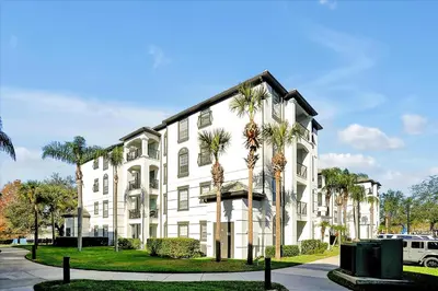 a white building with palm trees in front of it at Luxury Epic Universe Condo, Vista Cay - 3028 in Orlando