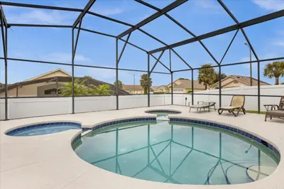 a large swimming pool with a glass roof at Cozy 5BR Near Disney Mickey Pool in Kissimmee