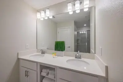a bathroom with two sinks and a large mirror at Apartamento 2Q | 10 Min da Disney | Piscina in Kissimmee