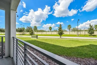 a porch with a fence and a field of grass at Apartamento 2Q | 10 Min da Disney | Piscina in Kissimmee
