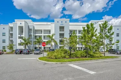 a parking lot in front of a large white building at Apartamento 2Q | 10 Min da Disney | Piscina in Kissimmee