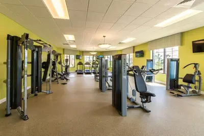 a gym with rows of treadmills and cardio machines at Apartamento 2Q | 10 Min da Disney | Piscina in Kissimmee