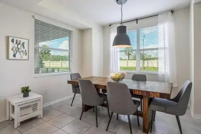 a dining room with a wooden table and chairs at Apartamento 2Q | 10 Min da Disney | Piscina in Kissimmee