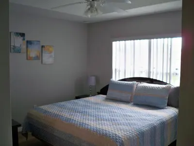 a bedroom with a bed with pillows and a window at Lovely Vacation Home with 3 bedrooms! in Kissimmee