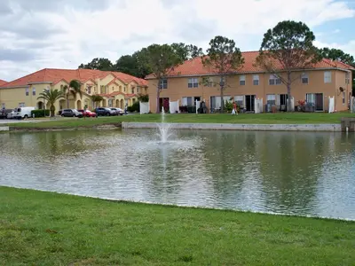 a pond with a fountain in front of a building at Lovely Vacation Home with 3 bedrooms! in Kissimmee