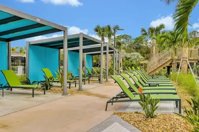 a row of green lounge chairs on a patio at NEW King Bed Disney Contemporary Townhouse in Kissimmee