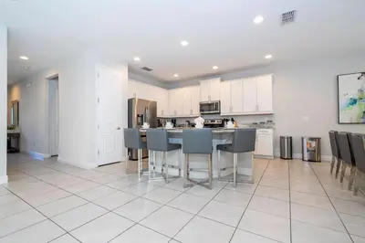 a kitchen with white cabinets and a table and chairs at Fantastic 5BR Villa Near Disney - Priv. Pool SPA in Orlando