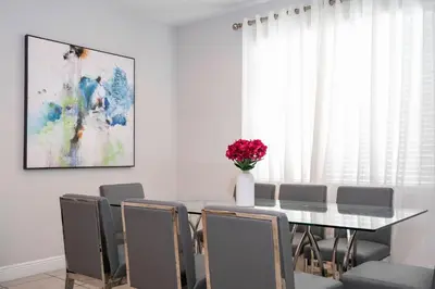 a dining room with a table with chairs and a vase of flowers at Fantastic 5BR Villa Near Disney - Priv. Pool SPA in Orlando