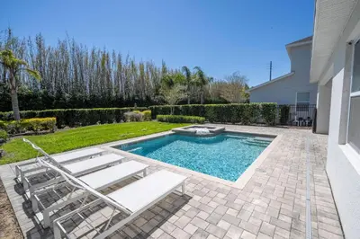 a swimming pool with two lawn chairs and a pair at Fantastic 5BR Villa Near Disney - Priv. Pool SPA in Orlando