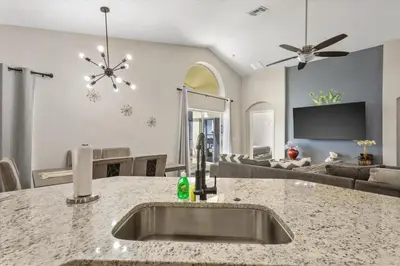 a kitchen with a sink and a living room at NEW King Bed Glow In The Dark Kid Cave in Kissimmee