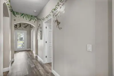 a hallway of a home with white walls and floral wallpaper at NEW King Bed Glow In The Dark Kid Cave in Kissimmee
