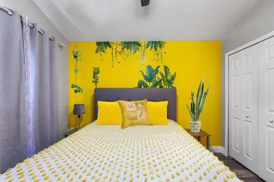 a bedroom with yellow walls and a bed with yellow pillows at NEW King Bed Glow In The Dark Kid Cave in Kissimmee