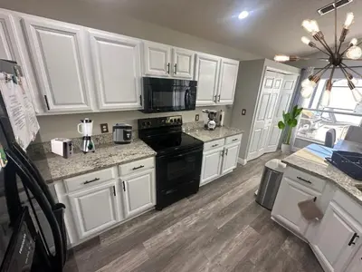a kitchen with white cabinets and black appliances at NEW King Bed Glow In The Dark Kid Cave in Kissimmee