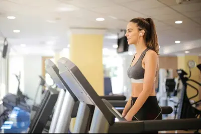 a woman walking on a treadmill in a gym at King Bed Theme Park Hotel Free Shuttle Included in Orlando