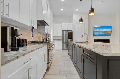 a large kitchen with white cabinets and marble counter tops at SpaceX BY R5 Shared Bath in Orlando
