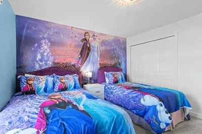 a bedroom with two beds and a painting on the wall at Stylish 4BR home Near Disney with Themed Rooms in Kissimmee