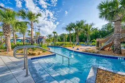 a pool with a slide and palm trees at Stylish 4BR home Near Disney with Themed Rooms in Kissimmee