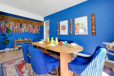 a blue dining room with a wooden table and blue chairs at Lilo & Stitch Themed Villa 10 Min to Disney! Heated Pool & Game Room in Orlando