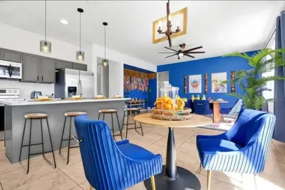 a kitchen and dining room with blue chairs and a table at Lilo & Stitch Themed Villa 10 Min to Disney! Heated Pool & Game Room in Orlando