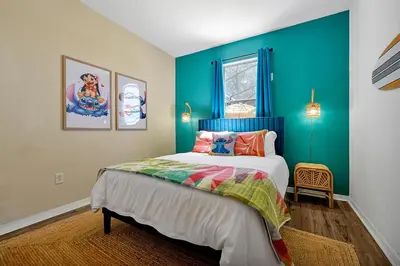 a bedroom with a bed and a blue wall at Lilo & Stitch Themed Villa 10 Min to Disney! Heated Pool & Game Room in Orlando