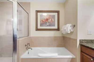 a bathroom with a bath tub and a picture of flowers at Villas North Charm in Orlando