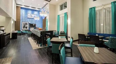 a restaurant with tables and chairs and a bar at Hampton Inn & Suites Orlando near SeaWorld in Orlando