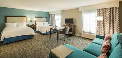 a hotel room with a bed and a couch at Hampton Inn & Suites Orlando near SeaWorld in Orlando