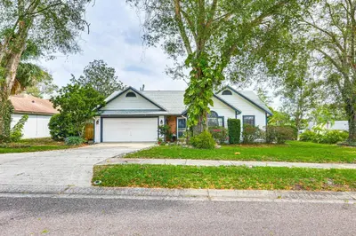 a white house with a garage on a street at Swim, Golf and Relax Lovely Home in Lake Mary in Lake Mary