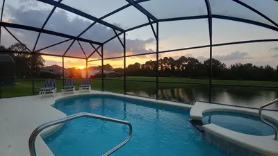 a large swimming pool with a view of a lake at Spectacular Lake View - Game Room- Close to Disney in Kissimmee