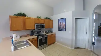 a kitchen with a sink and a stove top oven at Spectacular Lake View - Game Room- Close to Disney in Kissimmee