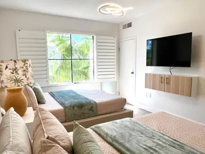 a bedroom with two beds and a flat screen tv at Unit near Epic Universe and Universal Studios - free parking in Orlando