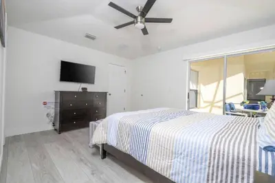 a bedroom with a bed and a ceiling fan at Sunshine Escape 20 minutes from Disney in Kissimmee