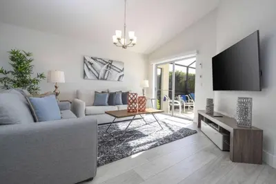 a living room with a couch and a flat screen tv at Sunshine Escape 20 minutes from Disney in Kissimmee