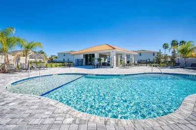 a swimming pool with a house in the background at Luxuosa Villa 4Q c/ Piscina | 10 min da Disney! in Orlando