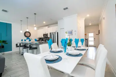 a white dining room with a white table and white chairs at Stunning 4Bd Close to Disney at Storey Lake Resort 2569 in Kissimmee