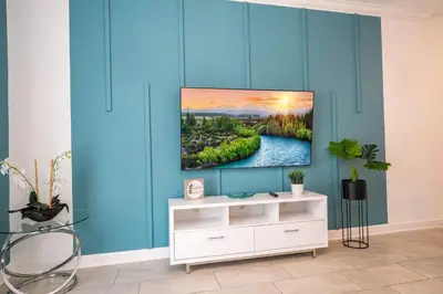a living room with a tv on a blue wall at Stunning 4Bd Close to Disney at Storey Lake Resort 2569 in Kissimmee