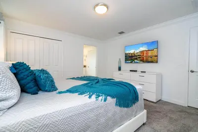 a bedroom with a bed with blue pillows on it at Stunning 4Bd Close to Disney at Storey Lake Resort 2569 in Kissimmee