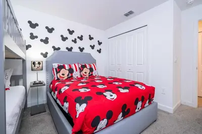 a bedroom with a red bedspread with cows on it at Stunning 4Bd Close to Disney at Storey Lake Resort 2569 in Kissimmee
