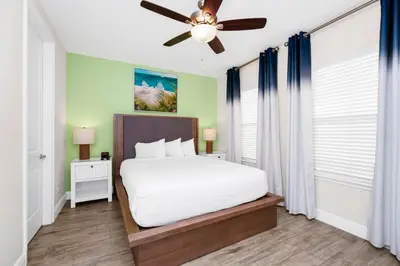 a bedroom with a white bed and a ceiling fan at Coastal Haven Villa Near Disney With Margaritaville Resort & Island H20 Waterpark Access - 2964Or in Orlando