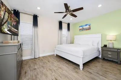a bedroom with a white bed and a ceiling fan at Coastal Haven Villa Near Disney With Margaritaville Resort & Island H20 Waterpark Access - 2964Or in Orlando