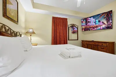 a bedroom with a large white bed and a window at Disney Dream Condo & Lake View Awaits! in Orlando