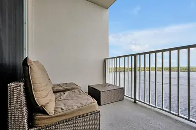 a balcony with a chair and a view of the water at Disney Dream Condo & Lake View Awaits! in Orlando